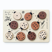 A beautifully crafted wooden ladybug puzzle featuring ten removable ladybug pieces, each with unique dot patterns, designed for counting and number matching.